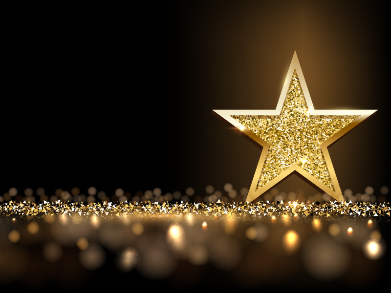 big golden star with sparkles on a dark background